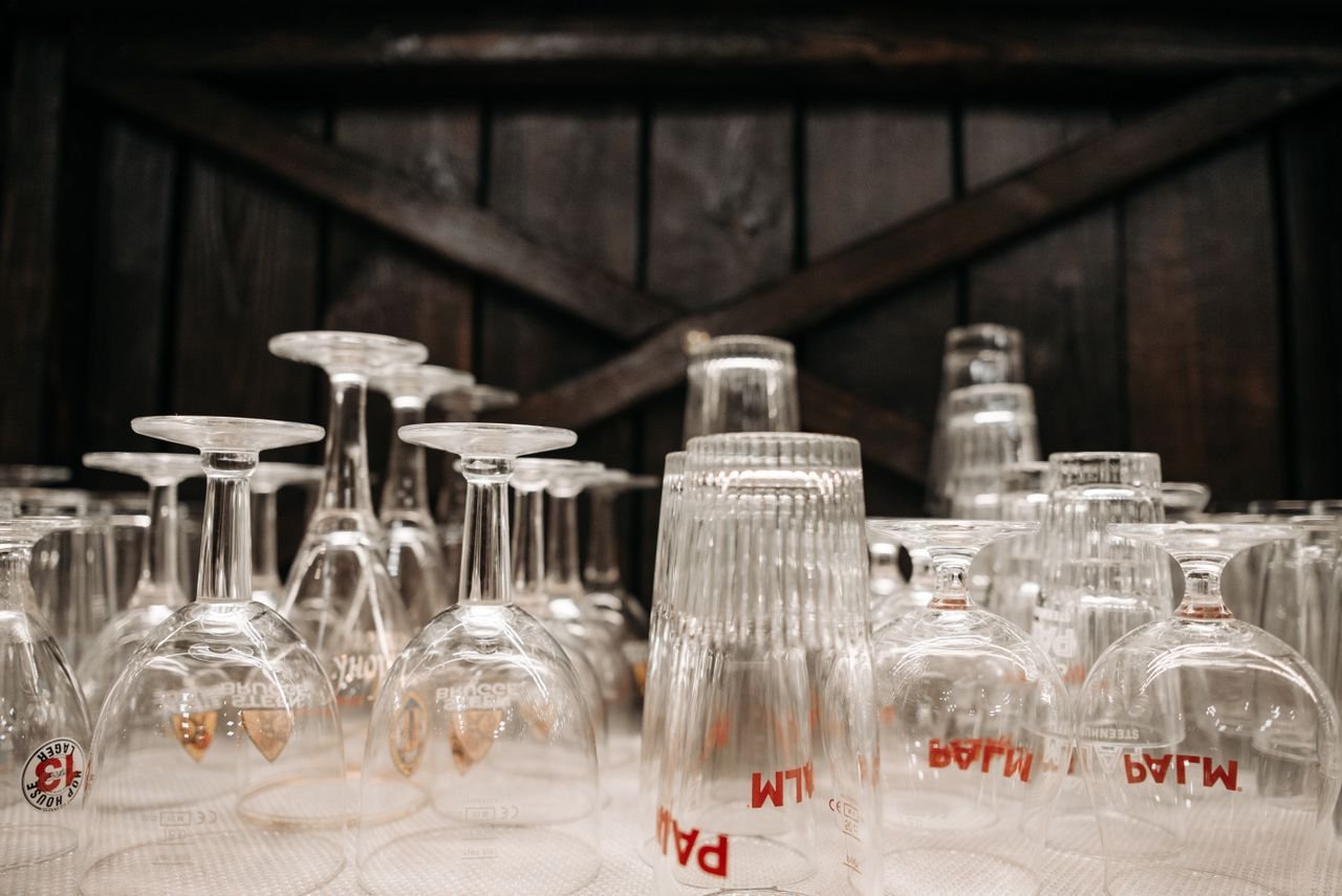 A variety of upside-down glasses in a rustic bar setting, ready for use.