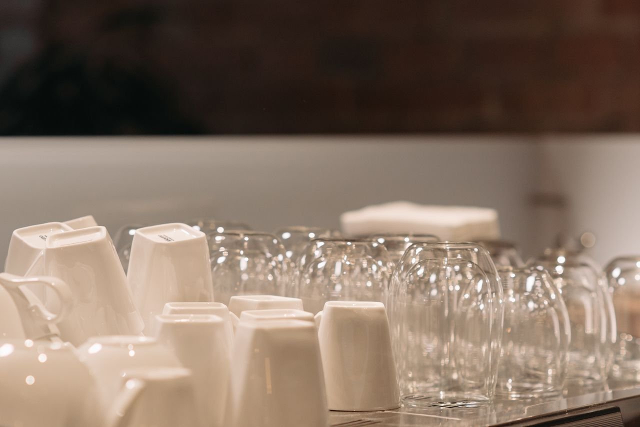 Clean and elegant arrangement of white cups and clear glasses on display.
