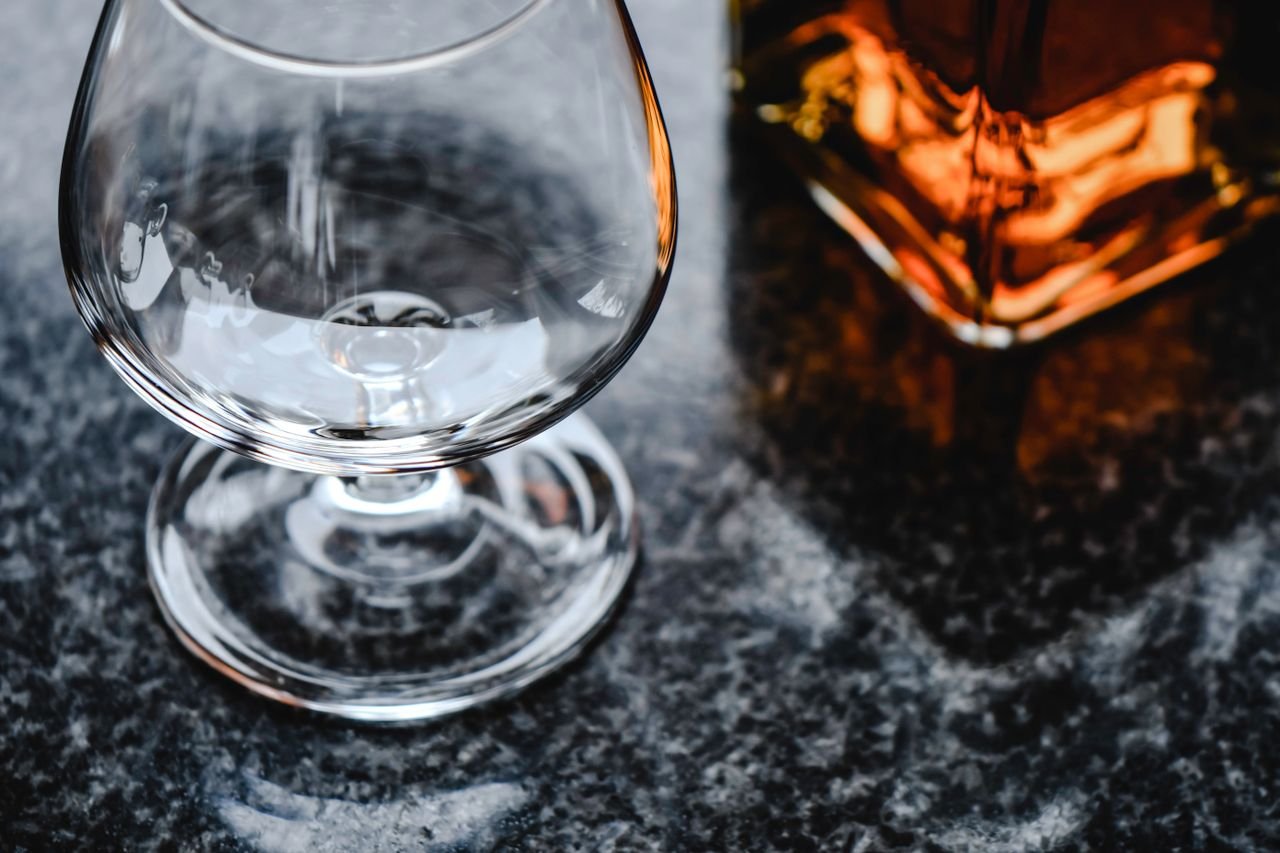 Close-up of a wine glass on a marble countertop with a hint of amber tones.