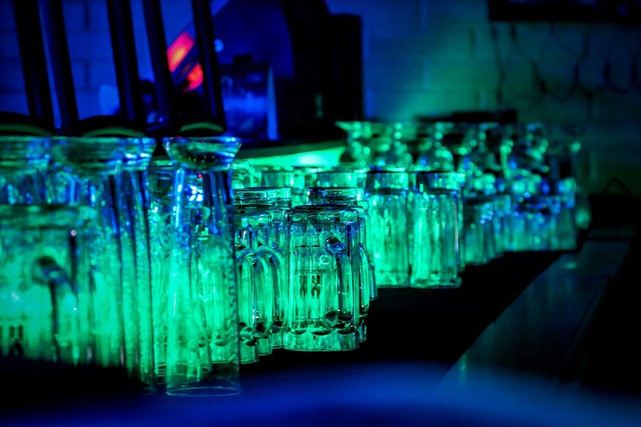 A vibrant display of illuminated drinking glasses in a Swiss bar, showcasing nightlife ambiance.
