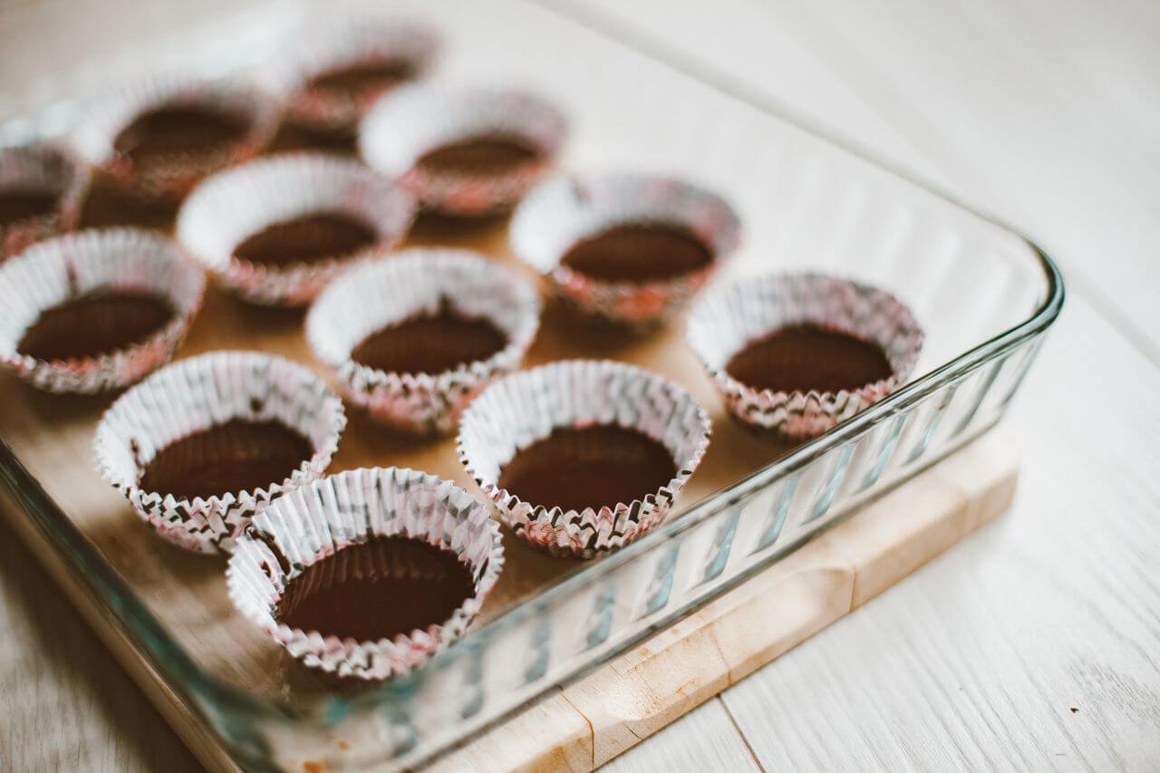 Glass dish with empty muffin liners ready for baking. Ideal for food preparation concepts.