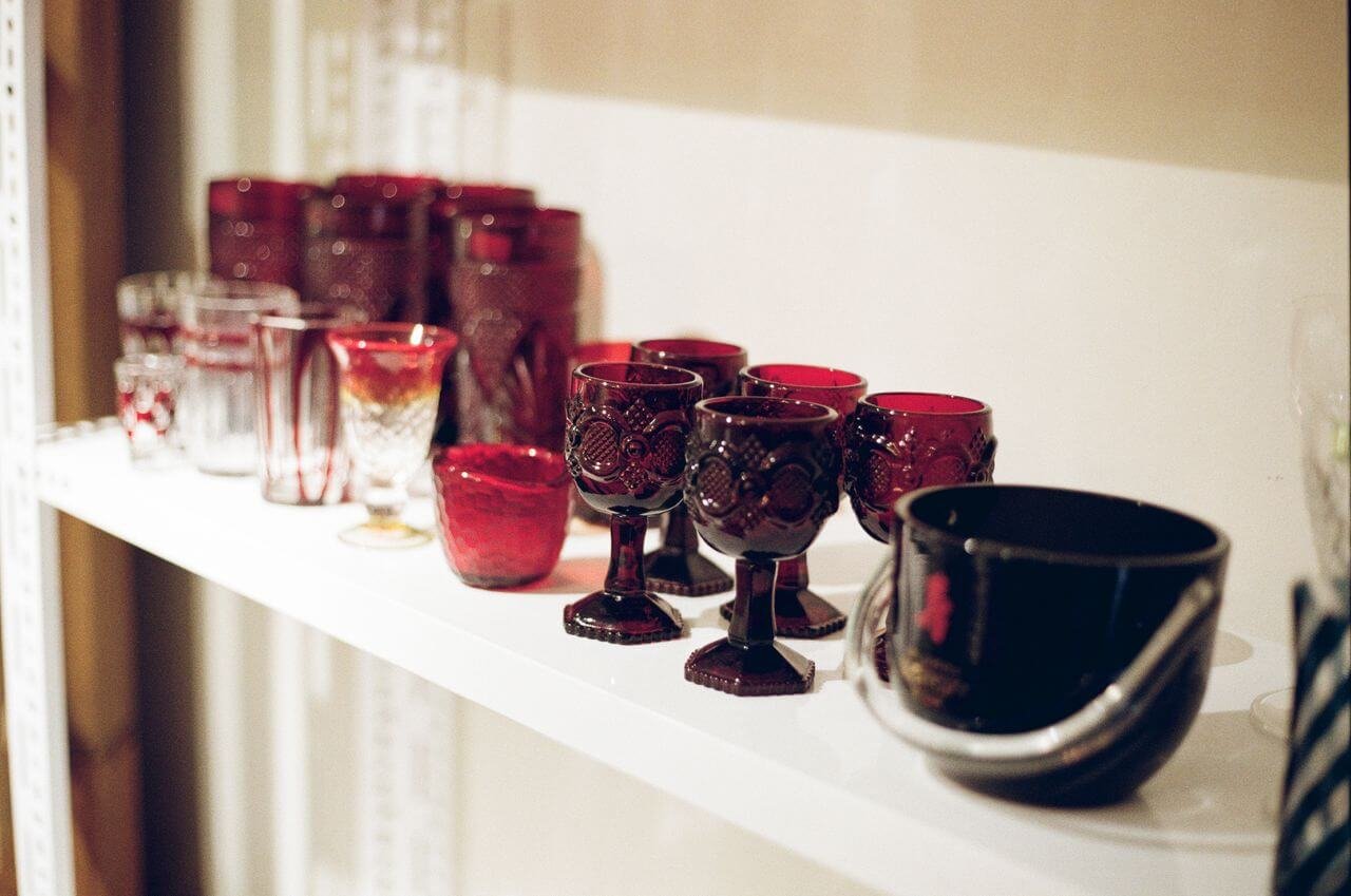 A collection of elegant red glassware displayed on a white shelf. Perfect for decor inspiration.