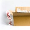Open cardboard box with fragile sticker and bubble wrap on a white surface.